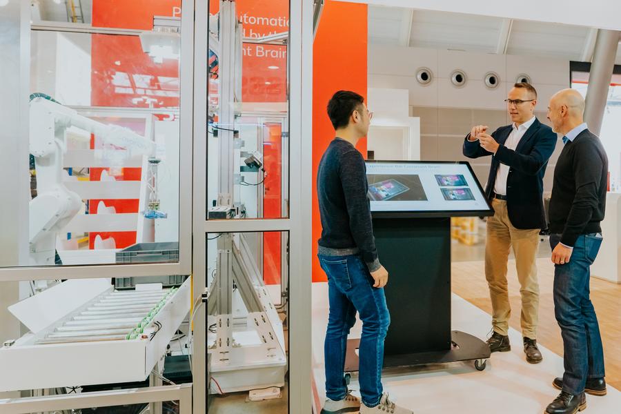 Kay Schiebur, Vorstand Services der Otto Group (Mitte rechts) will Covariant-Roboter (ganz links) im Otto-Fulfillment einsetzen (Otto Group)