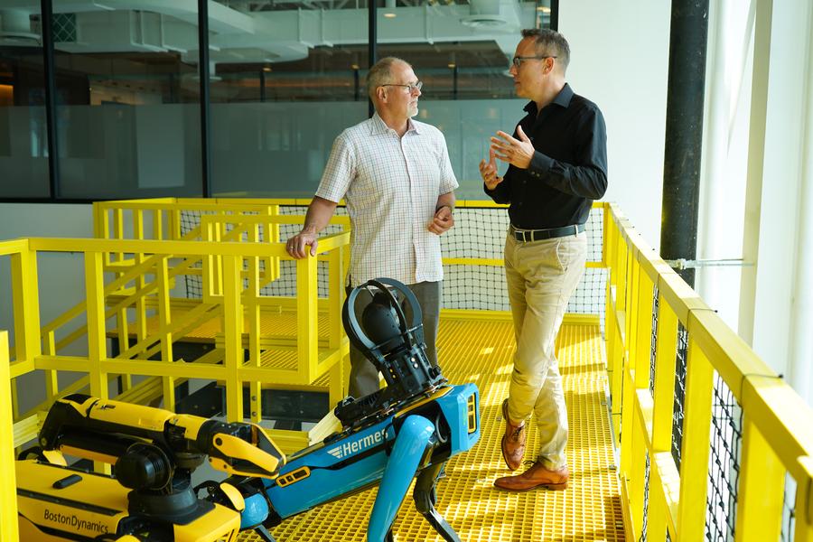 Der Hermes-Roboter (vorne), Robert Playter, CEO Boston Dynamics (links) und Kay Schiebur, Vorstand Services der Otto Group (rechts) über die künftige Arbeitsverteilung im Onlinehandel. Aktuell sollen die Vorstandspositionen noch von Menschen besetzt werden. (Ottogroup)